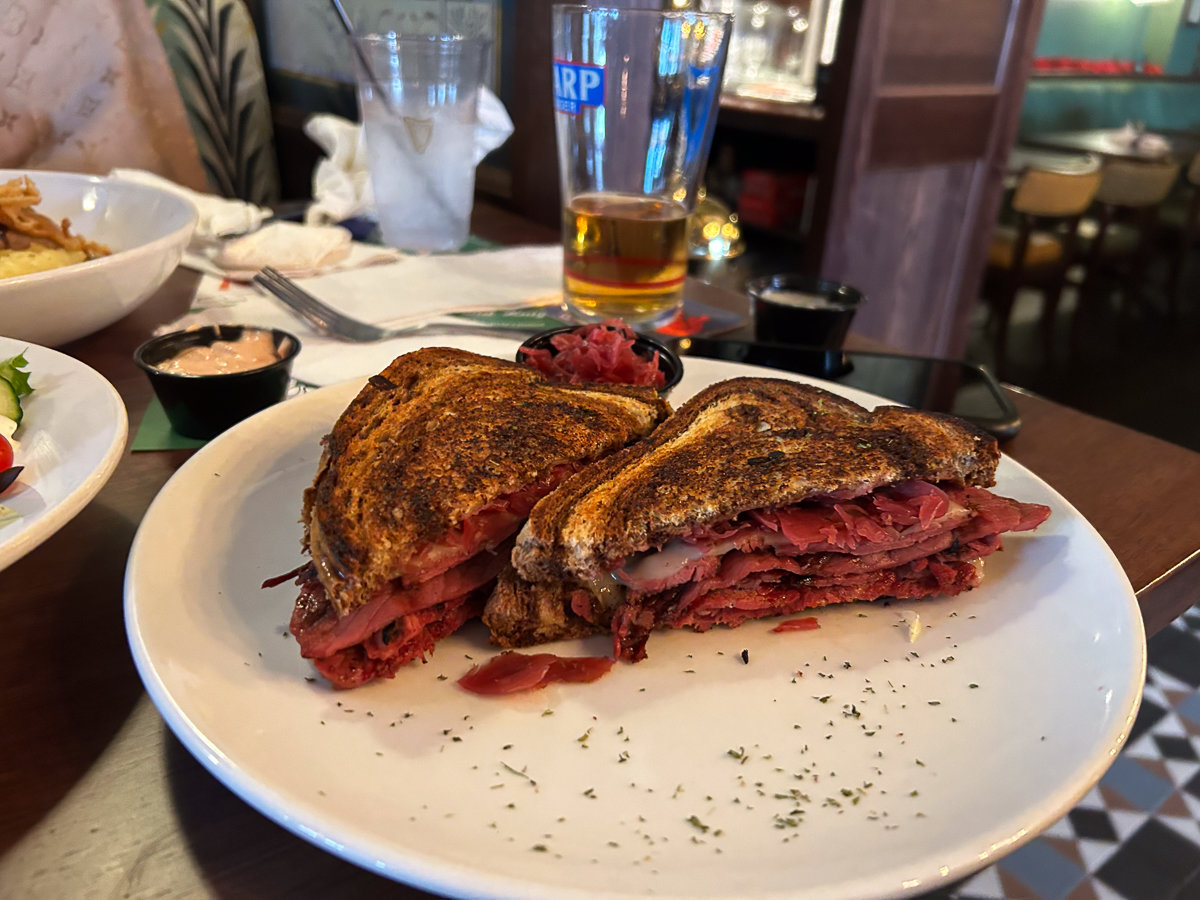 corned beef on toasted bread cut in half on a plate